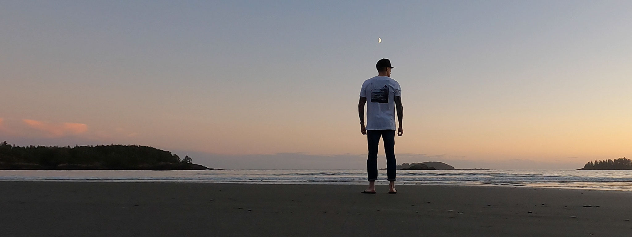 Man wearing Fault Line's Signature t-shirt on a beach at twilight.
