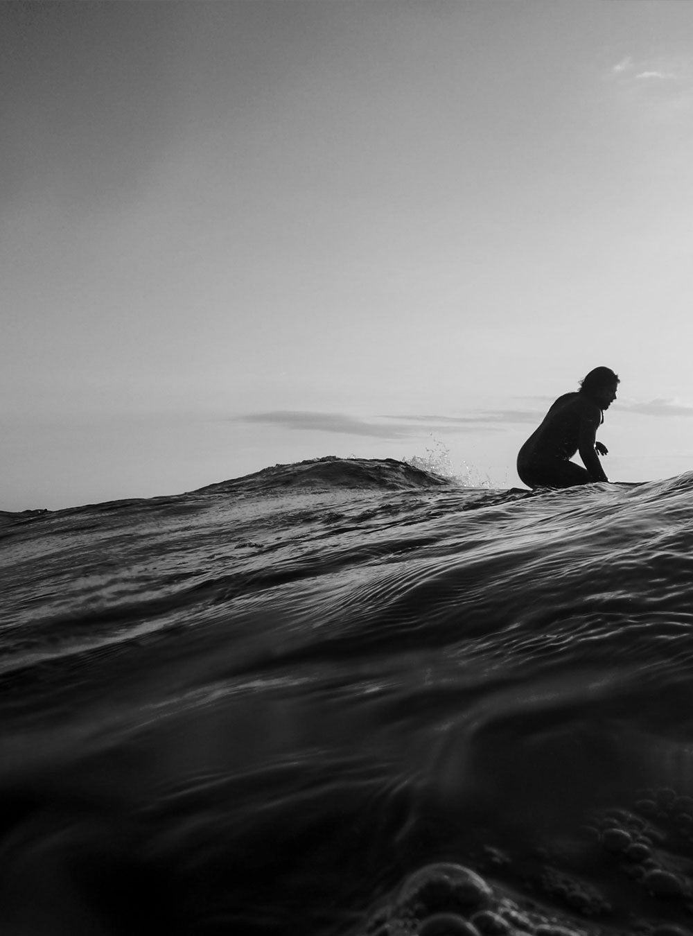 Man sat on a surfboard out at sea