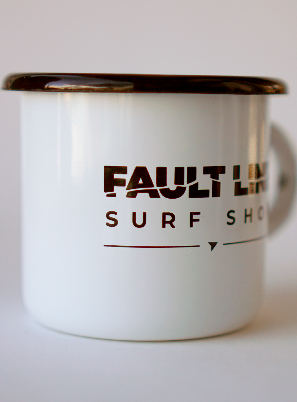 White enamel camping mug with a black rim and black Fault Line logo on both sides.